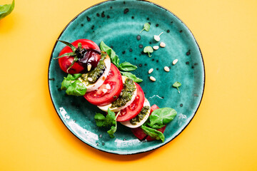 Wall Mural - Caprese salad. Tomatoes, mozzarella, basil, pesto, balsamic sauce