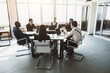 © xartproduction - Group of young business people working and communicating while sitting at the office desk together with colleagues sitting. business meeting
