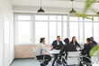 © xartproduction - Group of young business people working and communicating while sitting at the office desk together with colleagues sitting. business meeting