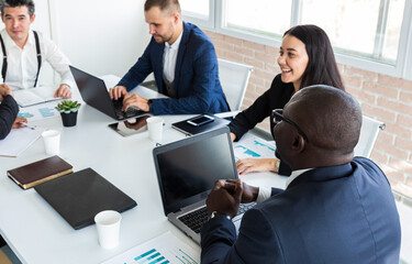 Wall Mural - Young business people working and communicating while sitting at the office desk together with colleagues sitting. business meeting