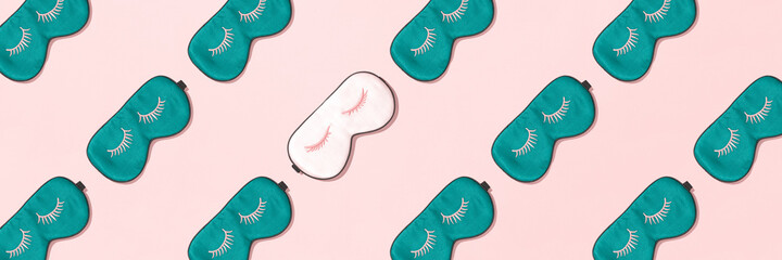 Banner made with sleeping mask pattern. Pink and green silk sleeping masks for eyes on pink background. Creative Top view Flat lay.