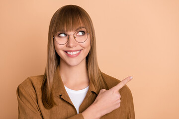 Sticker - Photo of dreamy pretty happy young woman look empty space point finger ad isolated on pastel beige color background