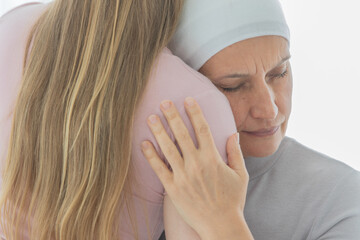 Wall Mural - A middle-aged breast cancer woman hug and cuddle her daughter with sadness and fear for her sickness