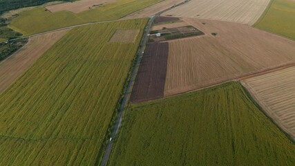 Wall Mural - drone video above spring countryside with agricultural fields, villages and road with cars. agricult