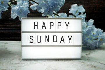 Wall Mural - happy sunday word in light box with flowers decoration
