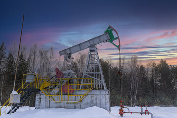 Oil rig energy industrial machine for petroleum in the sunset background for design. Oil pumpjack winter working. Oil pump under the sunrise sunset sky.