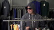 © Vital9c - A man in a hood and glasses steals a T-shirt from a store. Clothing store.