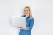 © Angelov - Portrait of a pretty young businesswoman holding a laptop on a white background