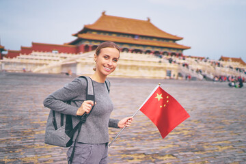 Wall Mural - Enjoying vacation in China. Traveling young woman with national chinese in Forbidden City, Beijing.
