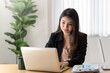 © amnaj - Young Asian accountant calculate and analyzes  work by using a laptop document placed at the office.