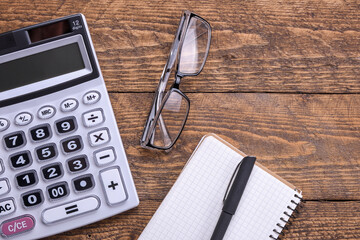 Calculator keypad with checks from the store from shopping on a wooden floor background. Top view. Copy space