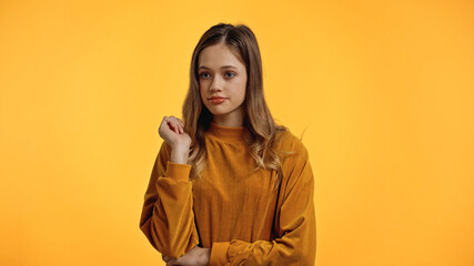 Wall Mural - teenager in sweater looking away isolated on yellow