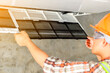 © RooM The Agency - Technician installing an air conditioning unit on a wall, Thailand