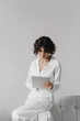 © Olena Bloshchynska - Business woman using digital tablet sitting on sofa in office.