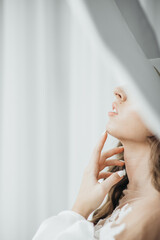 Wall Mural - A graceful woman posing with a large wide-brimmed hat.