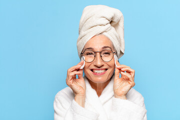 senior pretty woman facial cleaning or making up after shower wearing bathrobe