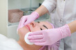 © Elena - cosmetology. Close up picture of lovely young woman with closed eyes receiving facial cleansing procedure