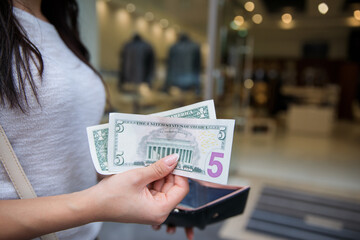 woman holding wallet with money