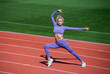 © be free - Athlete warming up. warm up on outdoor arena. training and workout. athletic female coach. woman sport trainer. healthy sporty lifestyle. health and energy. lady stretching in fitness sportswear