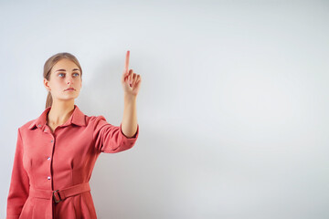 Woman touching an imaginary screen with her finger.Portrait of female college student touching something on copy space.Attractive young woman touching a virtual interface with her finger