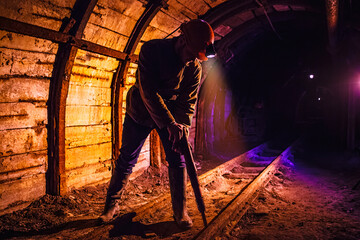 Miner working a jackhammer in a coal mine. Work in a coal mine. Portrait of a miner. Copy space.