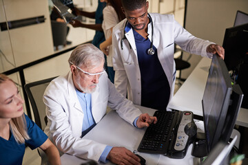 Professor Doctors discussing studying Mammogram film x-ray of patient 's head for brain, skull injury on computer, looking at screen of pc, try to save and solve problem