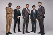 © Roman - 25 years old male leaders in classic suit posing at camera in studio. business people in formalwear, interracial group of successful men