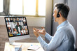 © Kateryna - Business meeting online. Successful businessman is negotiating with multiracial business partners on a video conference using a computer while sitting at his workplace