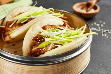 Canvas Print - Bao bun with hoisin chicken. Bamboo steamer on dark slate table. Chinese, asian, authentic food concept