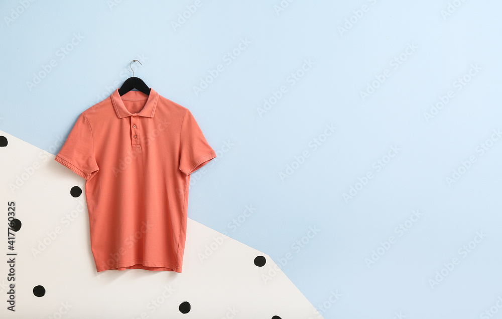 Stylish shirt hanging on color background