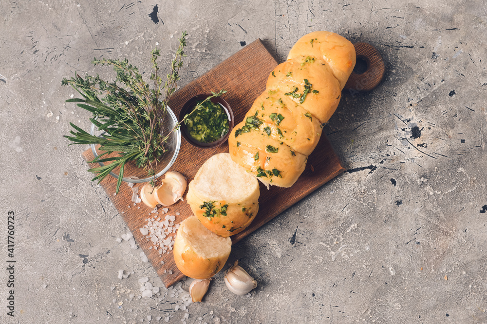 Fresh bread with garlic and thyme on grey background