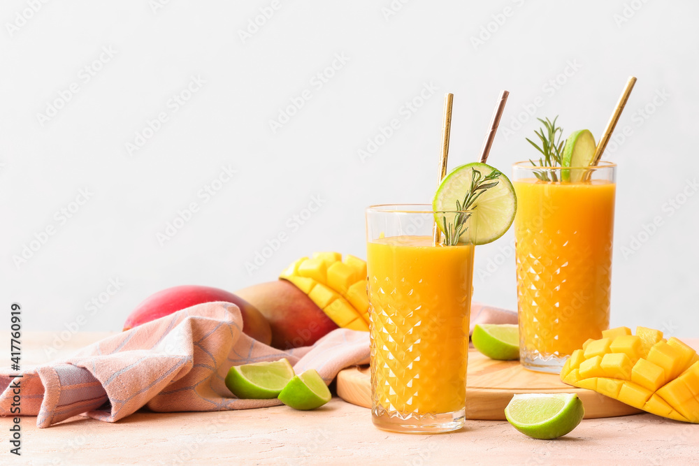 Glasses with tasty mango smoothie on table