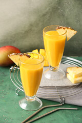 Glasses with tasty mango smoothie on color background