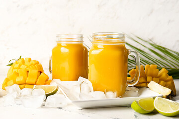 Wall Mural - Mason jars of tasty mango smoothie on light background