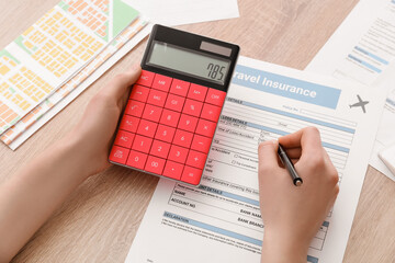 Woman with calculator counting travel expenses before journey