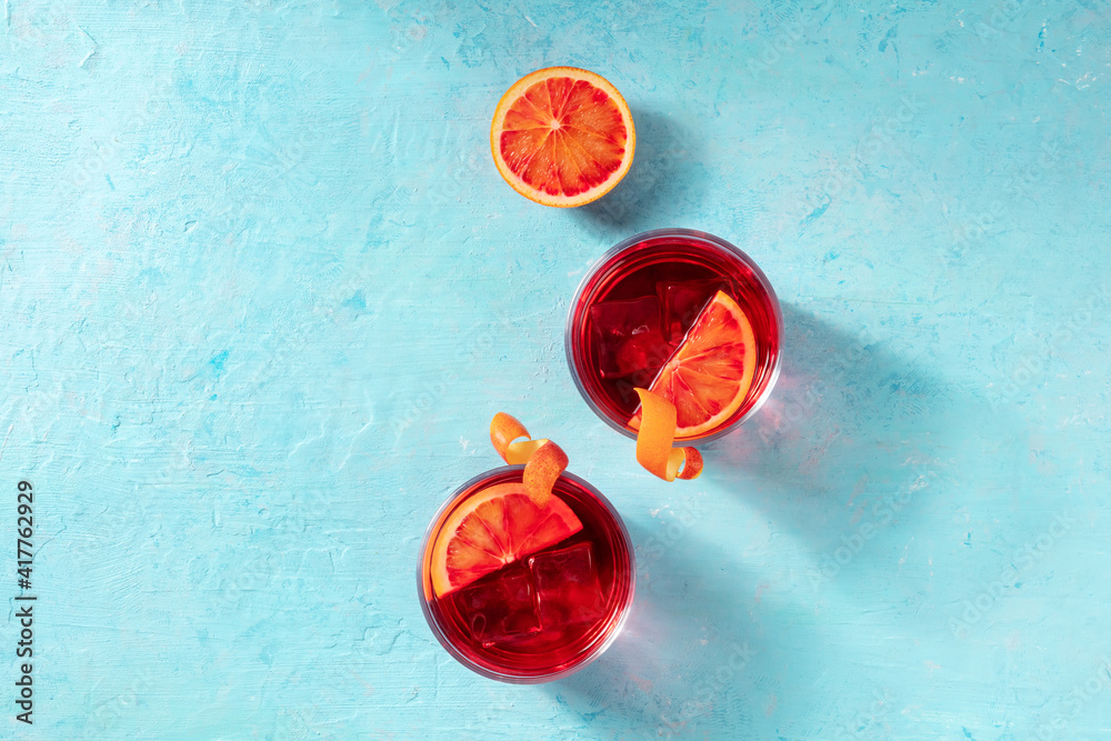 Orange cocktails, overhead flat lay shot on a blue background with a place for text - obrazy, fototapety, plakaty 