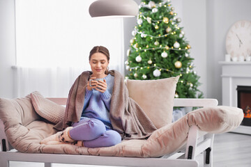 Sticker - Beautiful young woman drinking hot chocolate at home on Christmas eve