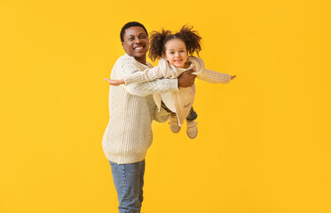 Canvas Print - Portrait of happy African-American father and his little daughter on color background