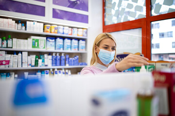 Wall Mural - Customer wearing protective face mask shopping in pharmacy drug store.