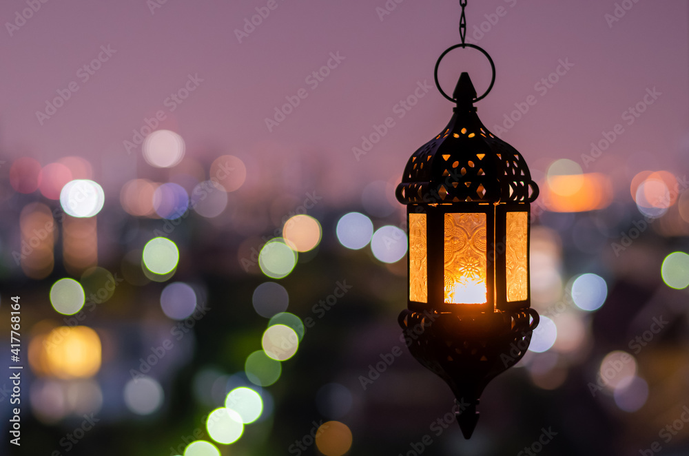 Hanging lantern with night sky and city bokeh light background for the Muslim feast of the holy month of Ramadan Kareem. - obrazy, fototapety, plakaty 