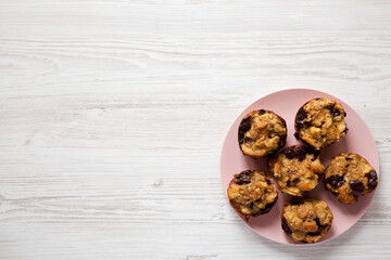 Homemade Chocolate Banana Bread Pudding on a pink plate on a white wooden background, top view. Flat lay, overhead, from above. Copy space.