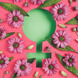 Female symbol with fresh spring gerbera flowers and leaves against two tone background. Creative Women's day, March 8th or feminism concept. Gender equality visual trend. Flat lay.