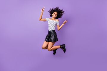 Poster - Full size portrait of attractive crazy dark skin girl fingers show v-sign hair flying isolated on purple color background