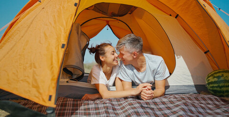 cute happy authentic moments couple in camping travel vacation. casual man and woman lying in tent t