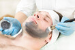 A man is made a cosmetic procedure mask to clean the healing skin of the face in a beauty salon.