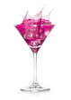 © popout - pink cocktail splashes out of a martini glass isolated on white background