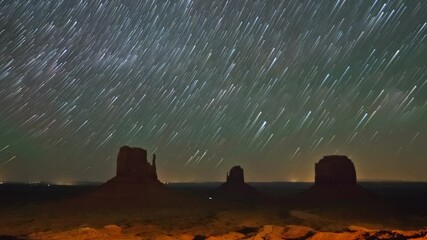 Wall Mural - night time lapse landscape with star trails in monument valley, usa
