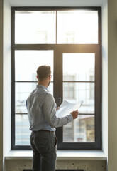 unrecognized man looking out of the window at work