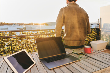 unrecognizable man enjoying the sunset after work from his rooftop terrace at home