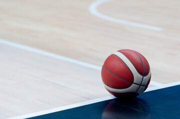 Wall Mural - An official orange ball on a hardwood basketball court